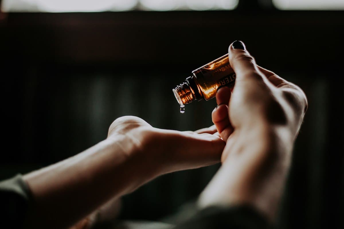 Hands holding an amber dropper bottle